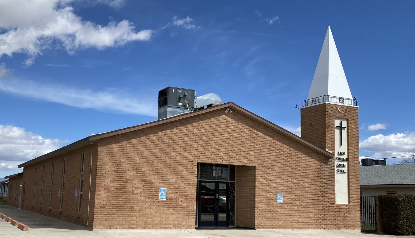 Red brick building with a white steeple and cross labeled First Southern Baptist Church.